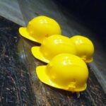 5 yellow hard hats on a table