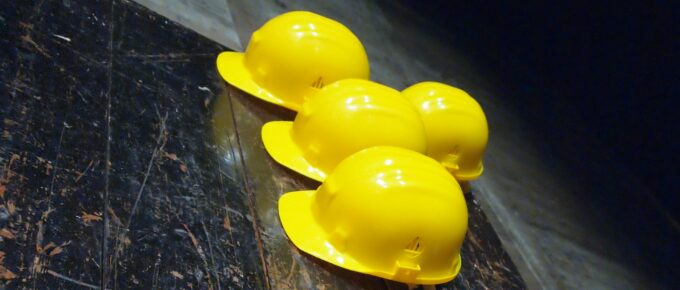 5 yellow hard hats on a table