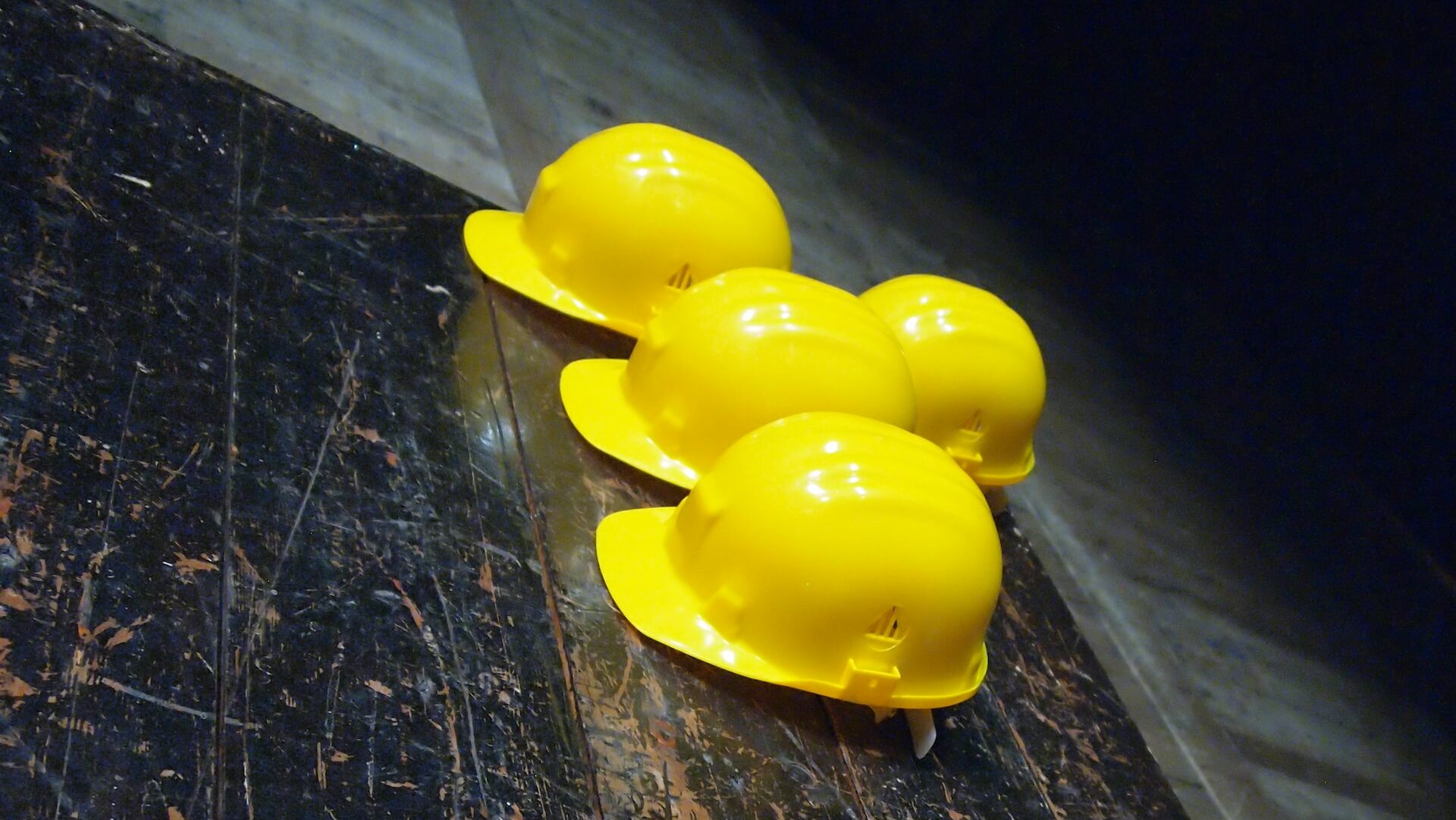 5 yellow hard hats on a table