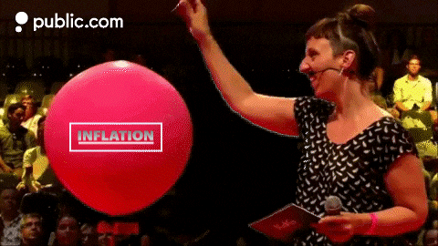 woman popping inflation balloon